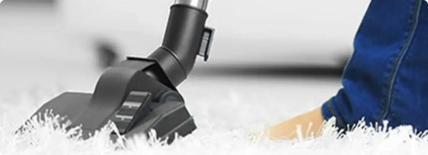 Close-up of a professional vacuuming a white carpet in Vandalia.